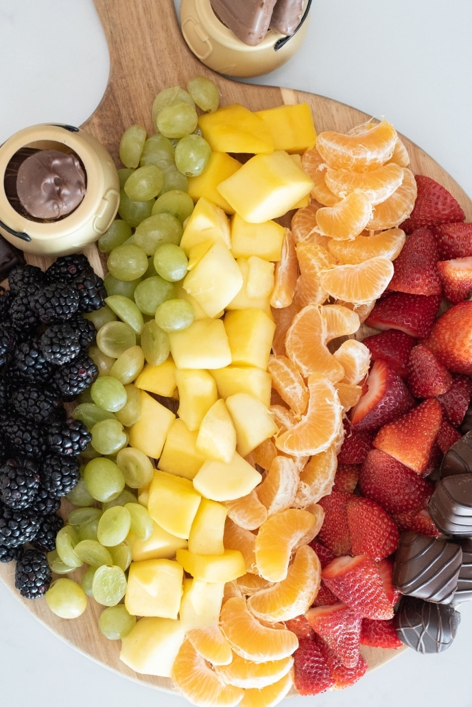 Fruits and chocolates on snack board.