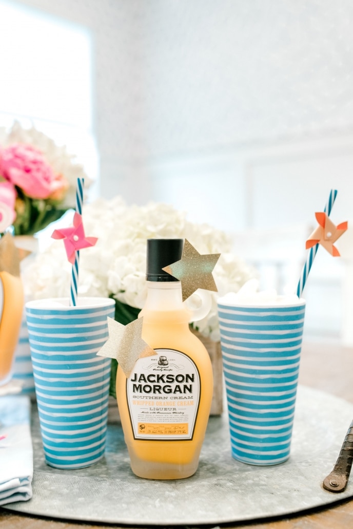 Bottle of Jackson Morgan Southern Cream with striped cups and straws.